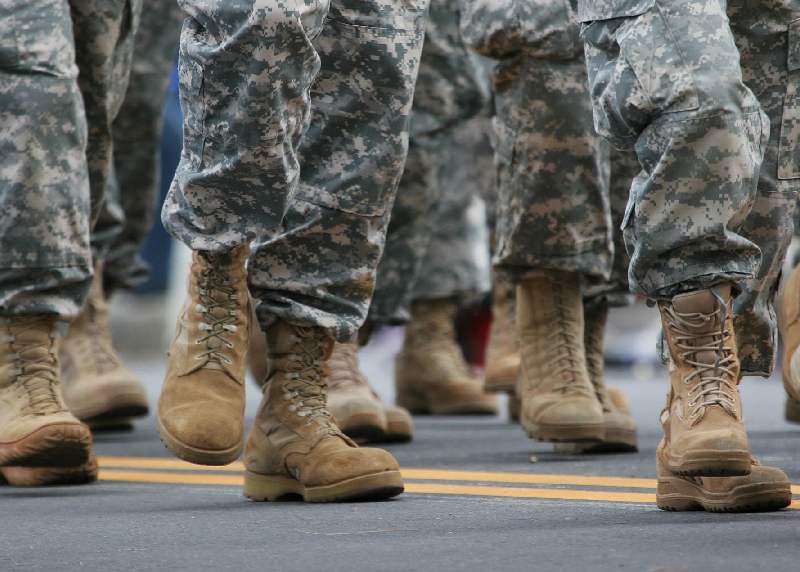 A close up of soldiers in fatigues walking down the street