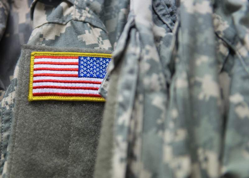A close up of the american flag patch on a military uniform.